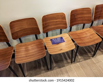 Empty Chairs In A Local Coffee Shop With A Sign 