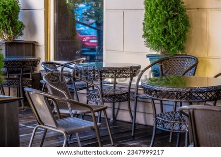 Empty chairs and a table on the veranda of the summer cafe.