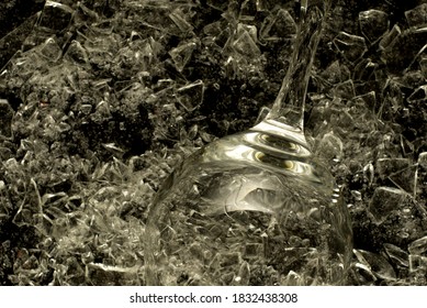 An Empty Champagne Glass Merged With Broken Glass Background. Wine Glass On Shards Of Glass In A Low Key.