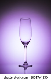 Empty Champagne Glass On Purple Background. Luxury Drink Glass In Purple Lights