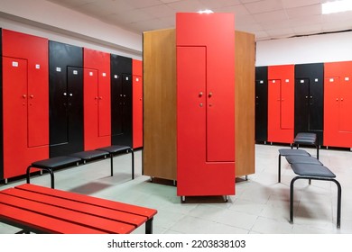 Empty changing room in fitness gym with group of red and black wooden lockers standing in a row by wall. Selective focus. Healthy lifestyle theme. - Powered by Shutterstock