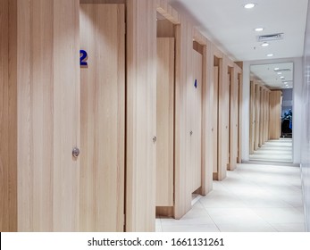 Empty changing rooms with wooden doors and white walls. Dressing rooms of a clothing store with no people. Shopping concept.