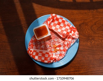 Empty Checkered Food Wrapper And Dip On Blue Plate