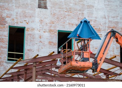 Empty Cherry Picker Lift With Folded Umbrella At Construction Site In New Orleans, LA, USA