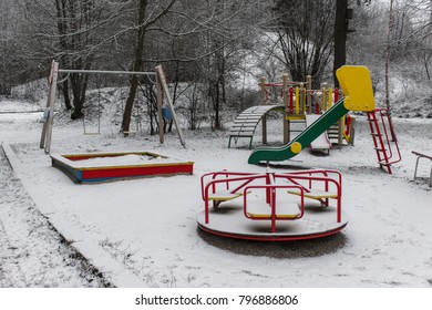 Empty Children Playground In Winter. Snow Covered Merry Go Round.