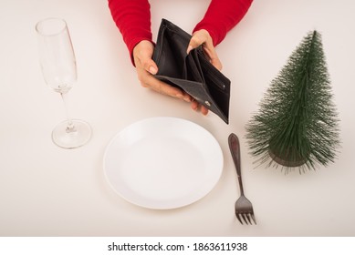 Empty Christmas Wallet. A Woman Is Holding A Purse With No Money On An Empty Holiday Table. The Financial Crisis During The Holidays.