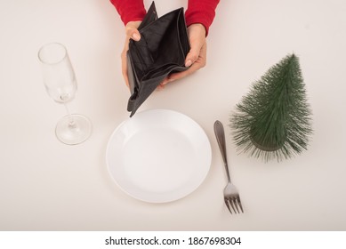 Empty Christmas Wallet. A Woman Is Holding A Purse With No Money On An Empty Holiday Table. The Financial Crisis During The Holidays.