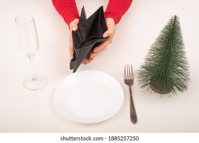 Empty Christmas Wallet. A Woman Is Holding A Purse With No Money On An Empty Holiday Table. The Financial Crisis During The Holidays.