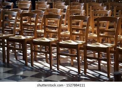 Empty Church Seats: Rows Of Chairs Are Bathed In Light And Shadows Within A Medieval Cathedral