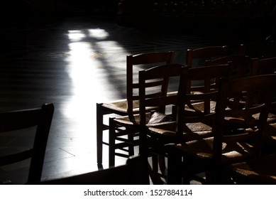 Empty Church Seats: Rows Of Chairs Are Bathed In Light And Shadows Within A Medieval Cathedral