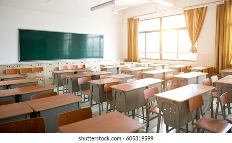 Empty classroom with chairs, desks and chalkboard. - Shutterstock ID 605319599