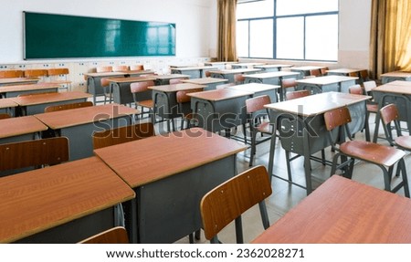 Empty classroom with desks, chairs and chalkboard.