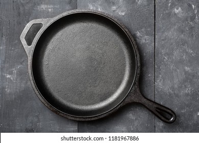 Empty, Clean Black Cast Iron Pan Or Dutch Oven Top View From Above On Black Wooden Table