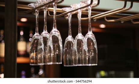 Empty clean wine glasses are hanging above the bar - Powered by Shutterstock