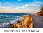 Empty coastal alley, a leafless tree  and rising sun over the sea waters,Black Sea coast,Bulgaria,November 6th 2013