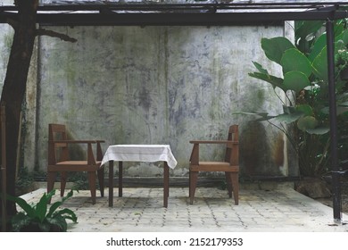 Empty Coffee Cafe Table With Wood Chair In Green Garden, Wooden Nature Decoration Design With Nature Background In Summer, By Vintage Furniture At Home Outdoor, Feeling Of Relax With Flower And Plant