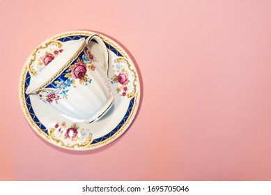 Empty Coffee Cup And Saucer Isolated On Pastel Pink Background With Copy Space. Top View Of Vintage Tea Cup With Floral Pattern Made Of Fine Bone China