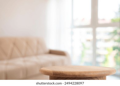 Empty coffee table with montage space near beige sofa and panoramic window in living room