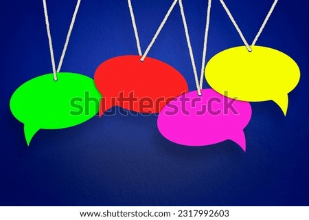 empty, colored speech bubbles hanging on a thread on a blue background