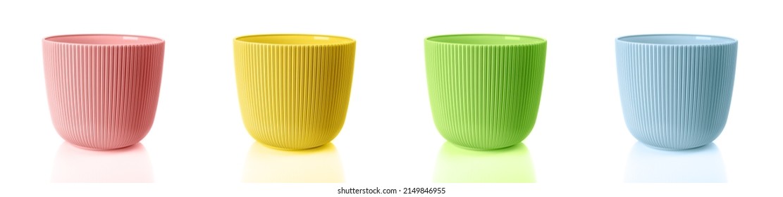 Empty colorful flower pots isolated on a white background. Set of vertical striped planters. Pink, yellow, green and blue plastic containers for indoor plants. Multicolored plant pots. Close-up.
