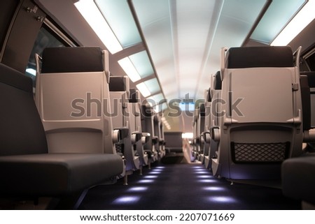 Empty comfortable modern seats inside business class cabin of fast speed European train. Interior of high speed train compartment.