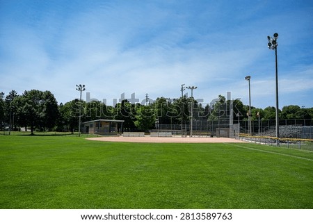 Empty community baseball field under blue sky.