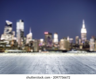 Empty concrete dirty rooftop on the background of a beautiful blurry NY city skyline at night, mockup