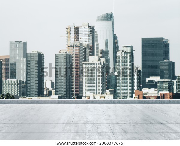 Empty concrete dirty\
rooftop on the background of a beautiful Los Angeles city skyline\
at morning, mockup