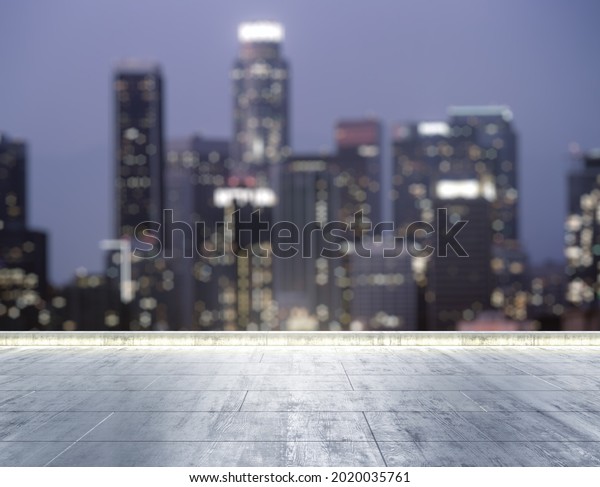 Empty concrete\
dirty rooftop on the background of a beautiful blurry Los Angeles\
city skyline at night,\
mockup