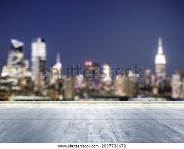 Empty concrete dirty\
rooftop on the background of a beautiful blurry NY city skyline at\
night, mockup
