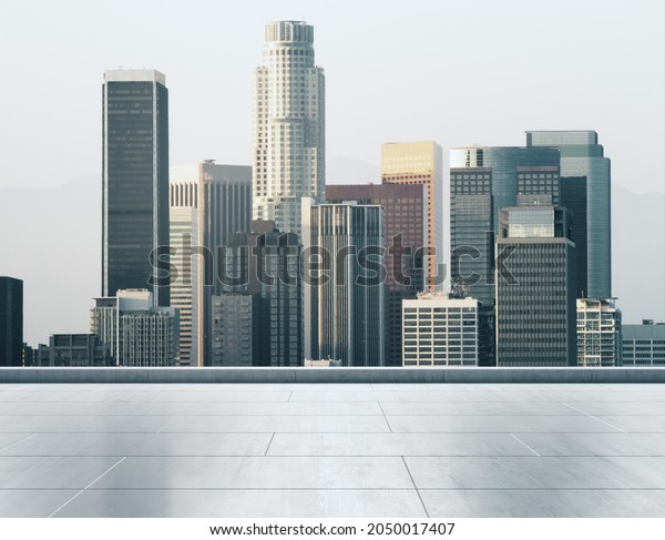 Empty concrete rooftop on the\
background of a beautiful Los Angeles city skyline at daytime,\
mockup