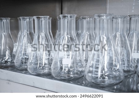 Empty conical Erlenmeyer flasks on the shelf ready for chemical analysis. Laboratory glassware.