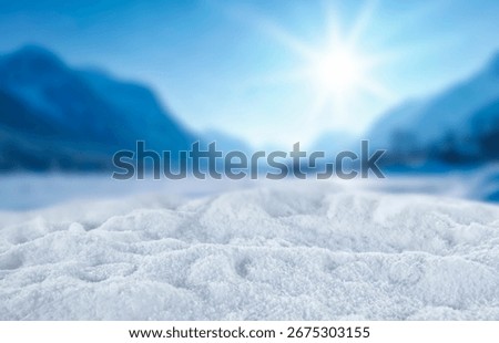 Empty copy space on fresh snow with background of frozen winter mountains and clear blue sky on sunny day. Concept of winter holidays, seasonal product placement, cold weather and mountain nature.
