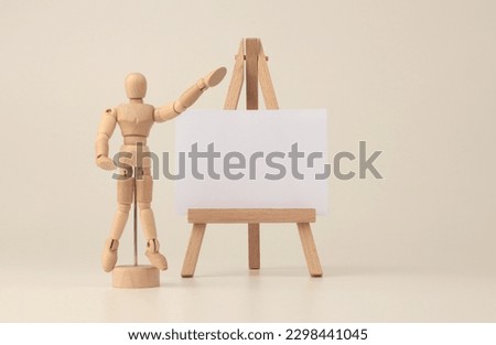 Empty copy space paper canvas on small wood easel. Art Light beige background.