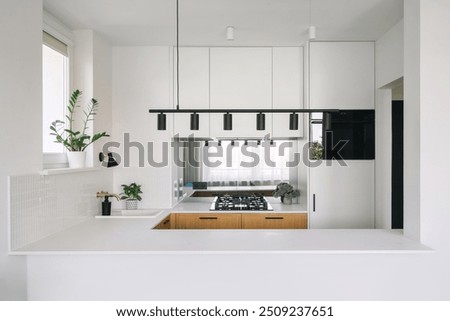 Empty and copy space table with spacious kitchen on background. Modern interior design with clean lines, island table and minimalist decor. Household appliance for cooking food at home