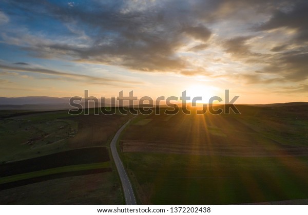 Empty country road in\
sunset.