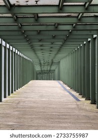 Empty covered walkway with repeating columns and perspective lines, modern architectural corridor with copy space