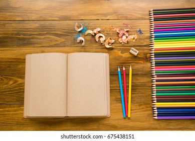 Empty craft note and crayons on wood