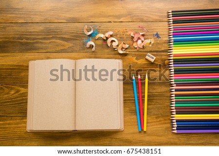 Empty craft note and crayons on wood