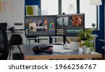 Empty creative workplace with professional computer placed on desk, dual monitor setup. Video editing start up studio company agency with no people in it and post production software on pc displays