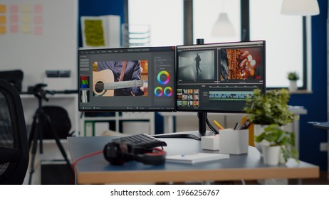 Empty creative workplace with professional computer placed on desk, dual monitor setup. Video editing start up studio company agency with no people in it and post production software on pc displays - Shutterstock ID 1966256767