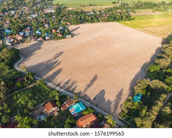 Empty Crop Field Near Rural Village In Asian Country