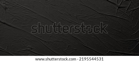Empty crumpled wet black paper blank texture copy space wall horizontal long background.