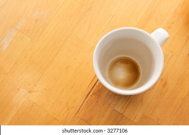 An Empty Cup Of Coffee Viewed From Above On A Wooden Table.