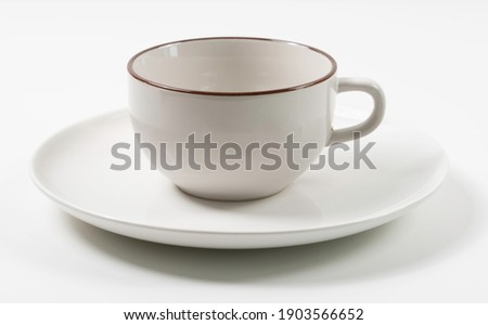 Empty cup placed on a white plate.