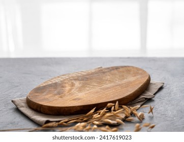 Empty cutting board on a blue textured background in front of a window with a dry branch and a napkin. Board for serving food or preparing homemade and healthy food. Free space for text. - Powered by Shutterstock