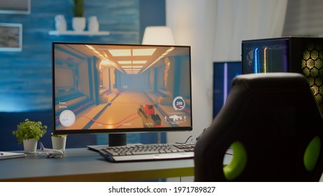 Empty Cyberspace With RGB Powerful Personal Computer With First-person Shooter Game On Screen In Gaming Studio With No People At Desk Prepared For Online Esports Tournament. Room With No People