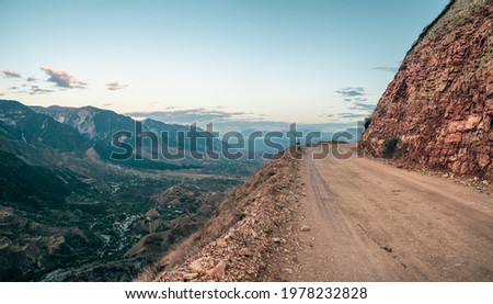 Empty dangerous narrow cliffside  mountain road. Dangerous off road driving along mountain edge and steep cliff. Dagestan.