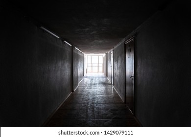 Empty dark corridor with light at the end