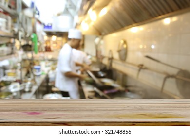 Empty Dark Wood Table With Motion Chefs Of A Restaurant Kitchen Background